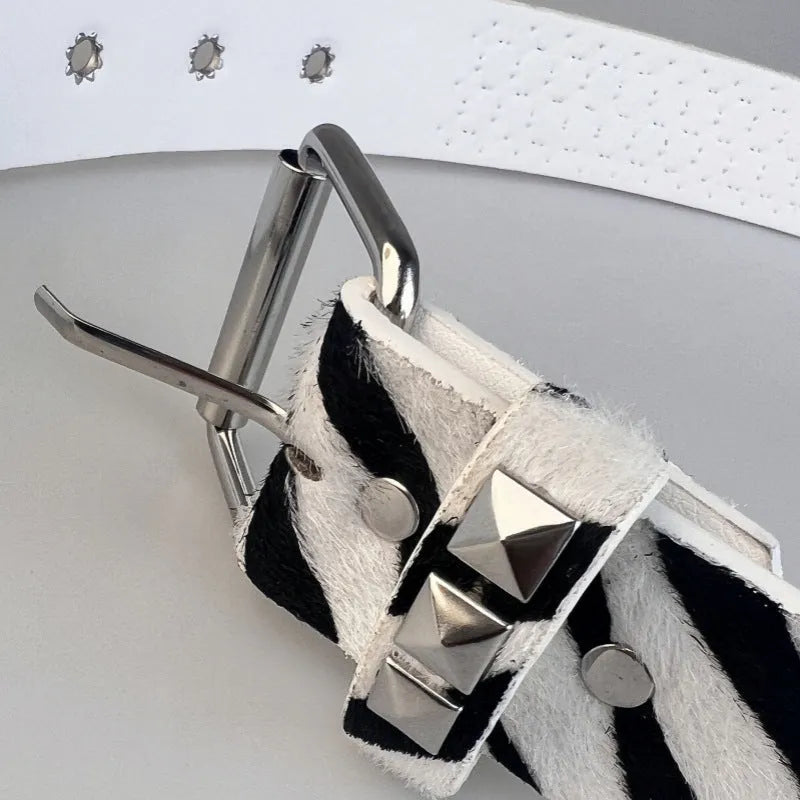 Women's punk fashion belt with metal rivets and pyramid studs in leopard print pattern, showing adjustable buckle