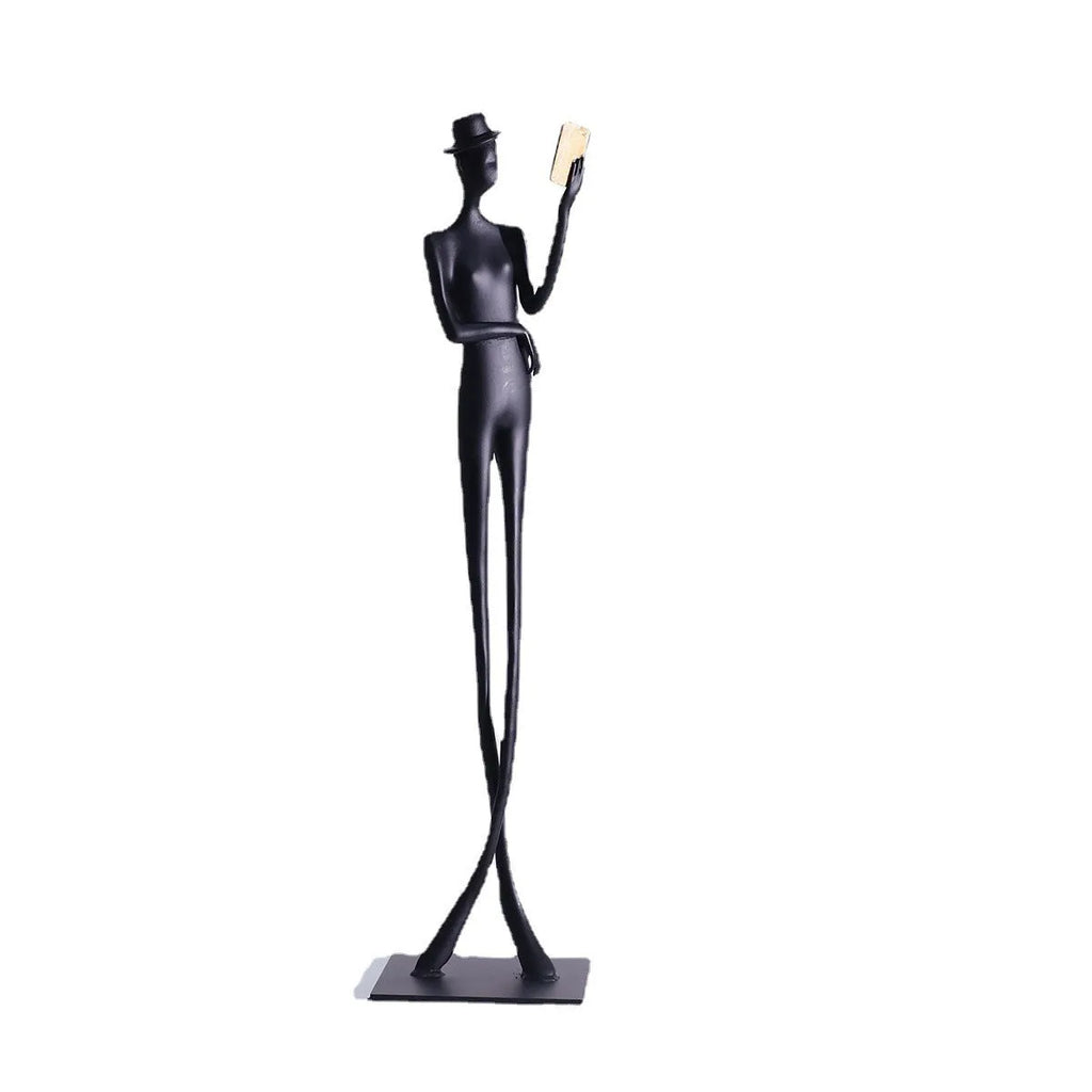 Black aluminium desktop sculpture of reading woman figure measuring 12x12x51cm