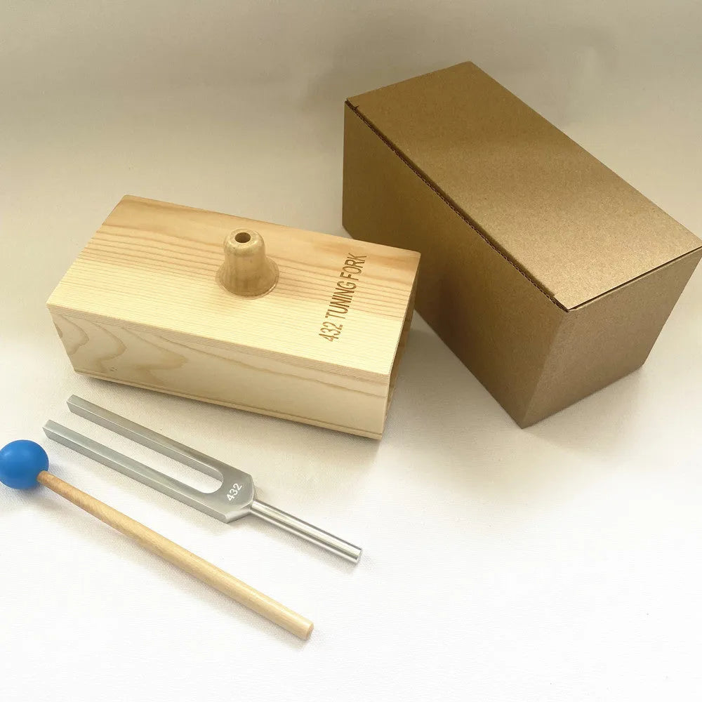 432Hz aluminium tuning fork and small speaker set on kraft paper packaging