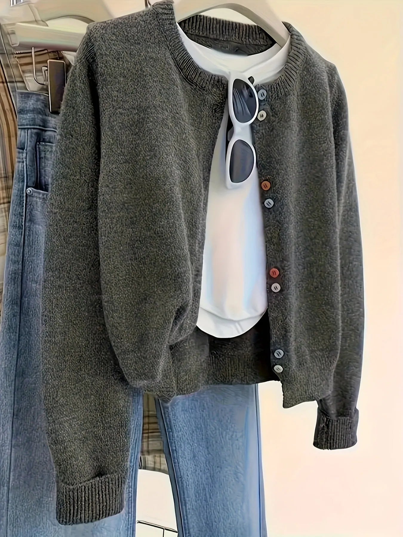 Dark grey women's polyester cardigan sweater with button front and long sleeves laid flat.