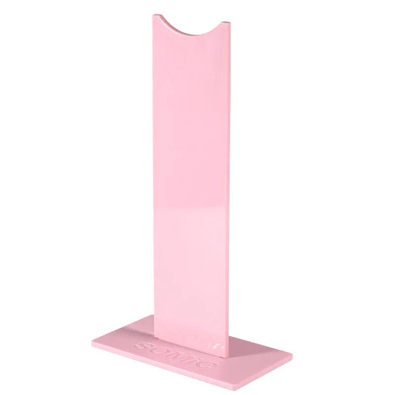 Pink and black detachable head-mounted gaming headset bracket on a desk