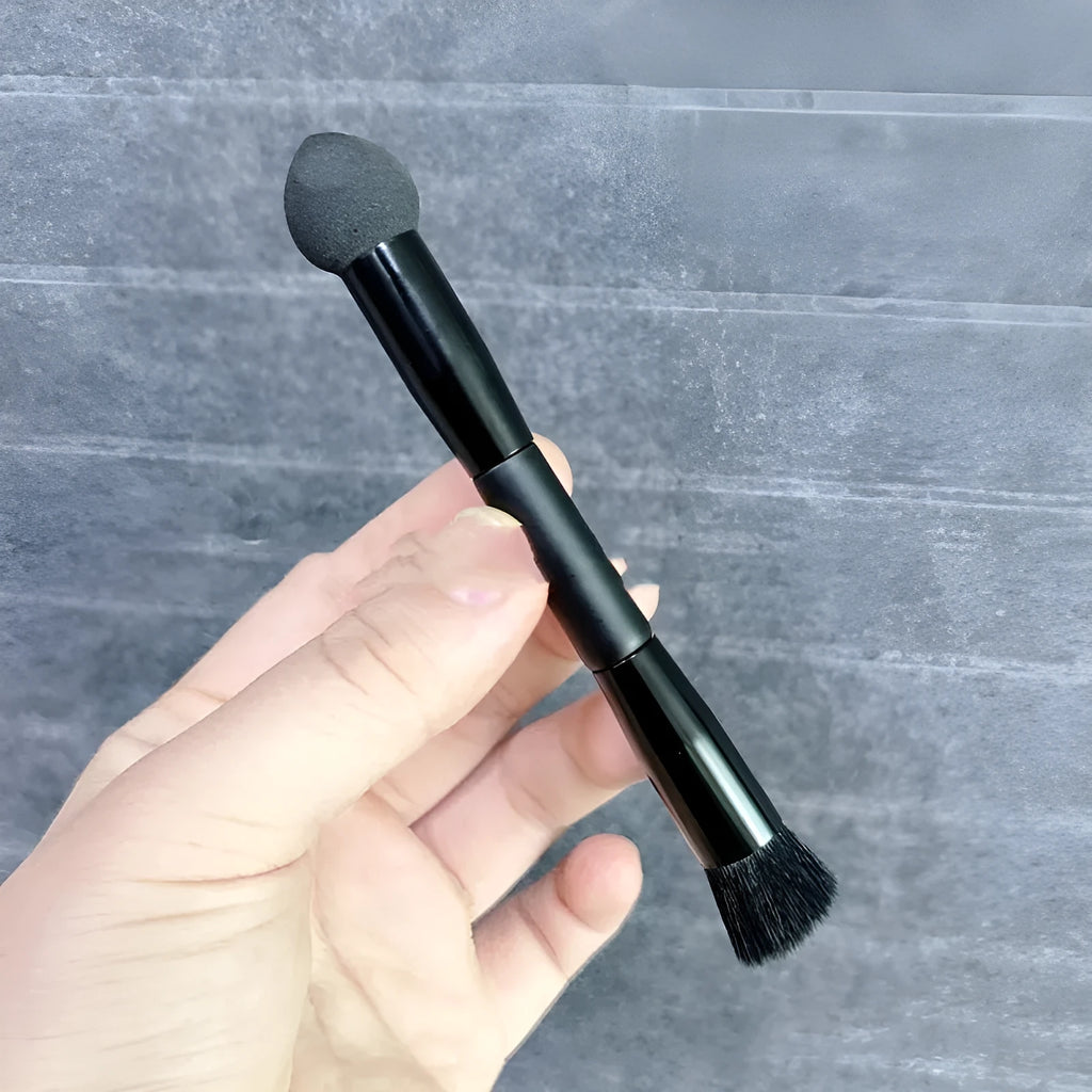 Black sponge-tip concealer brush with a wooden handle for covering dark circles.
