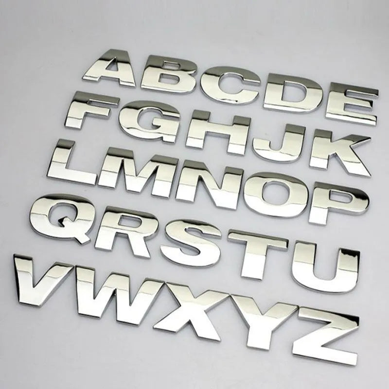 Close-up of a silver metal zinc alloy 3D letter 'A' car bumper sticker, approximately 2.5cm in size.