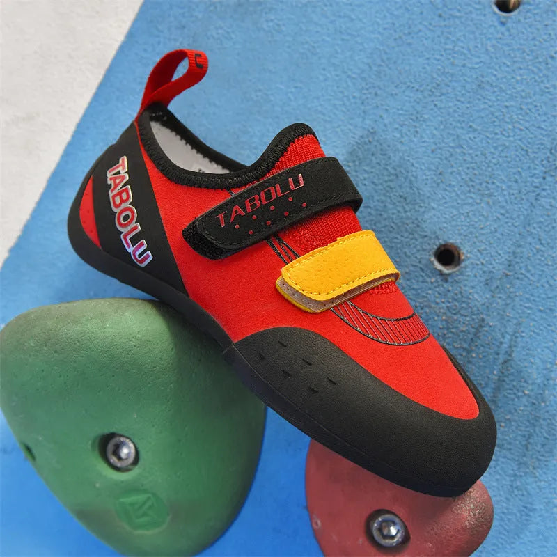 Beginner rock climbing shoes with Velcro strap and rubber sole in black and red colour combination