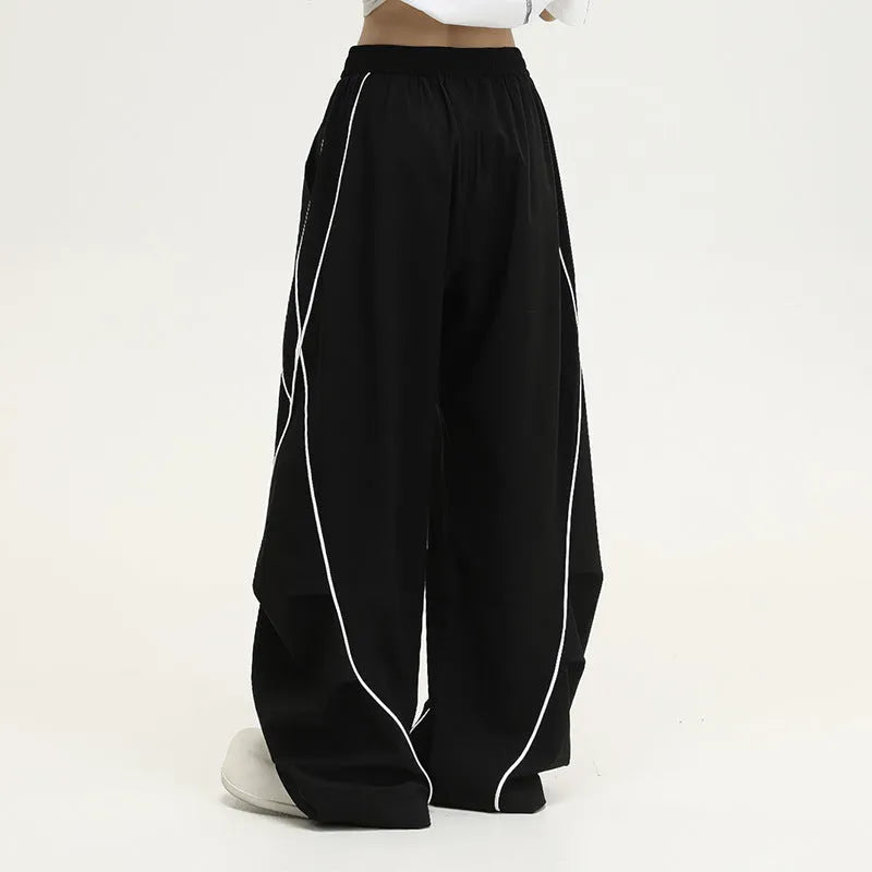 Black striped pleated hip hop trousers with wide-leg design shown flat