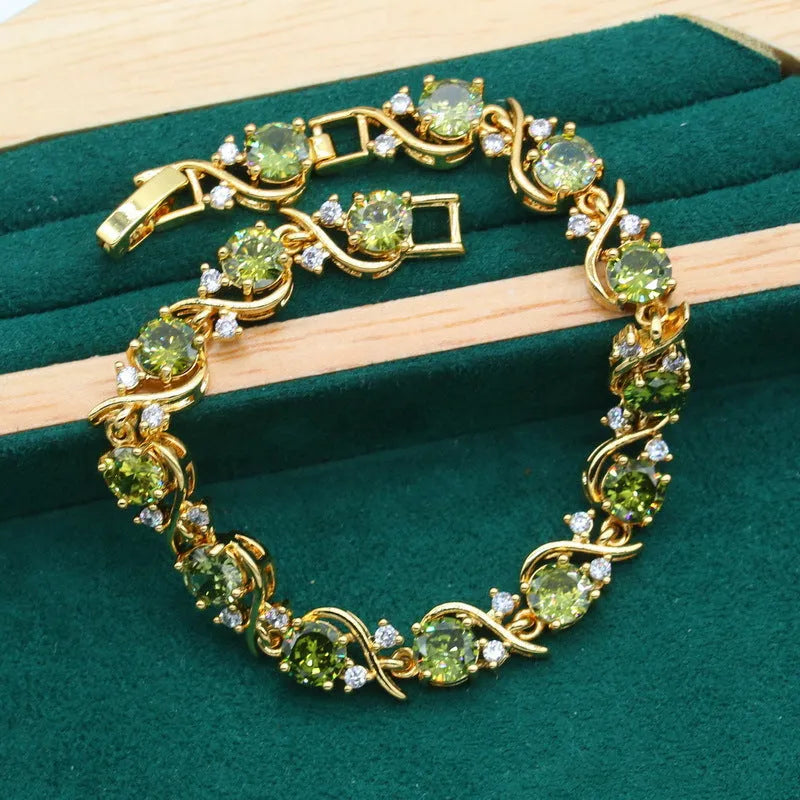 Olive green zircon rhinestone jewellery set on snake bone chain with crown pendant, plus matching earrings and ring.