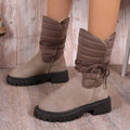 Women's black suede snow boots with chunky heel and lace-up design showing fleece lining