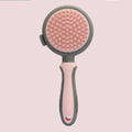 Double-sided pink cat brush with release button and a separate black flea comb on a white background.