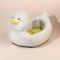 Blue duck-shaped fluffy pet bed for a small dog on a wooden floor.