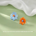 A pair of cartoon-style flower stud earrings made from alloy, shown in blue and orange colour contrast.