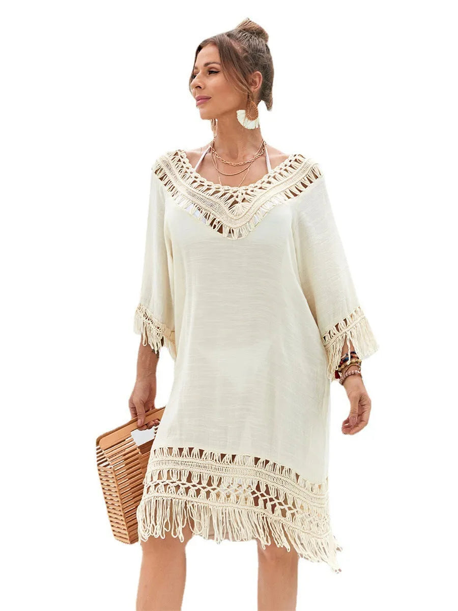 Apricot coloured hand-crocheted women's beach dress on a hanger.