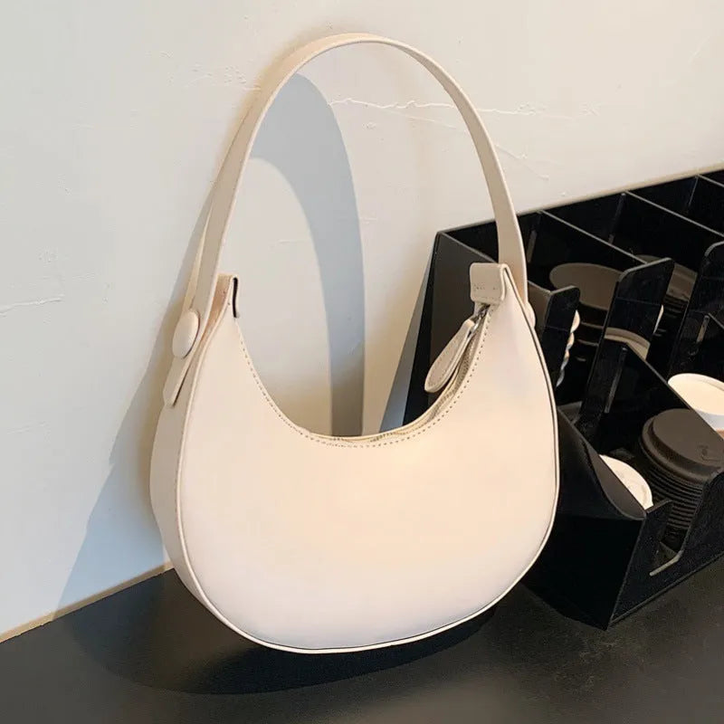 Women's retro PU leather shoulder bag in dumpling shape with zipper pocket, showing cream yellow colour option