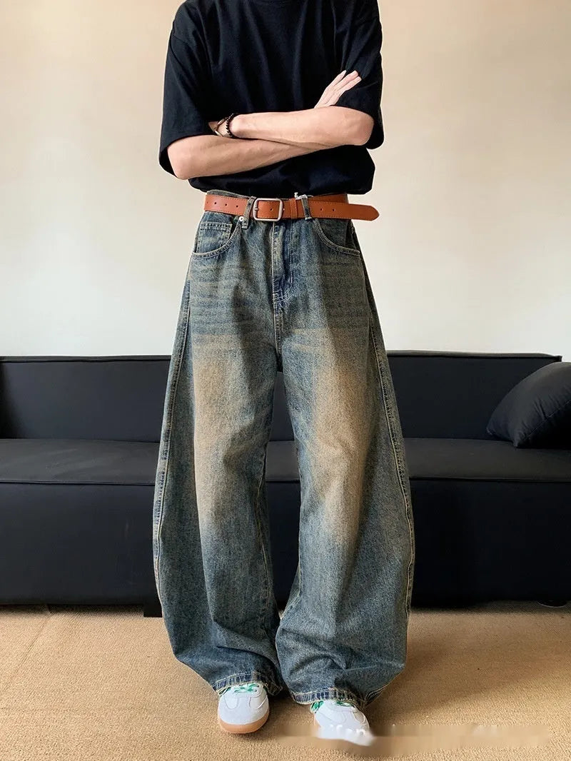 Man wearing retro blue distressed wide-leg denim jeans with a slimming fit and mid waist design.