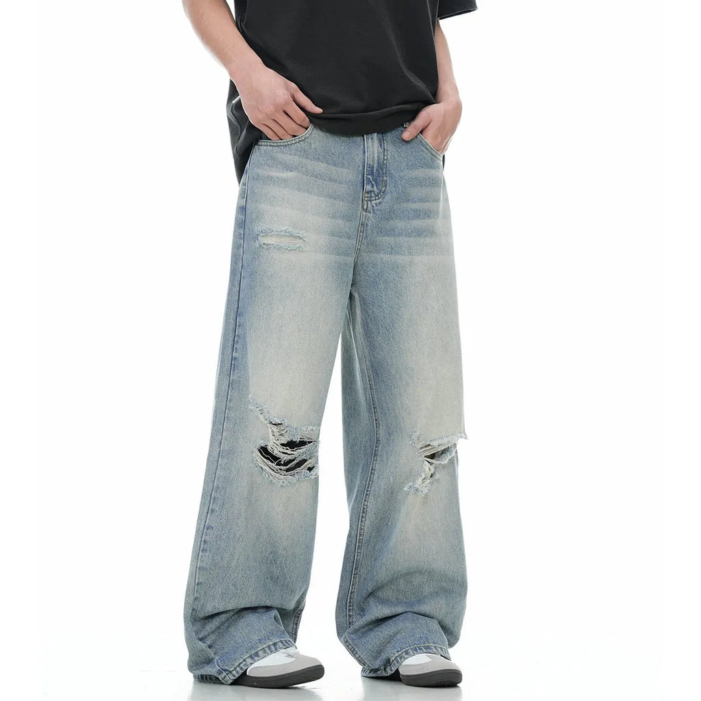 Men's blue straight-leg jeans with ripped details on the legs, showing a zipper fly.