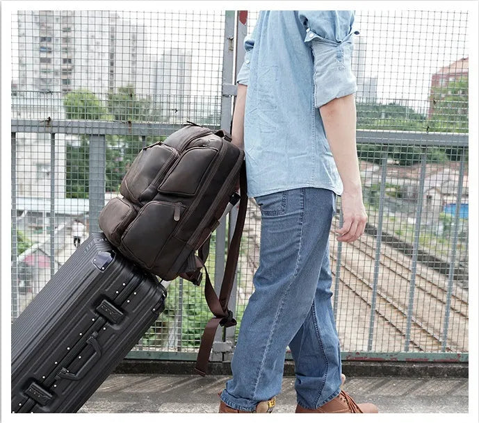 Dark brown leather backpack for 17-inch laptops with multiple compartments and shoulder straps
