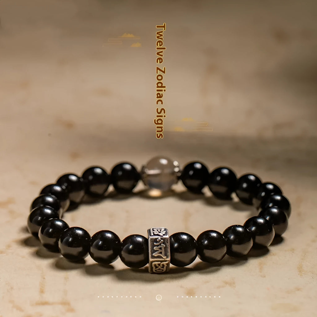 Old Pit Obsidian 8mm bracelet with detailed metal zodiac animal and Buddhist bodhisattva charms.