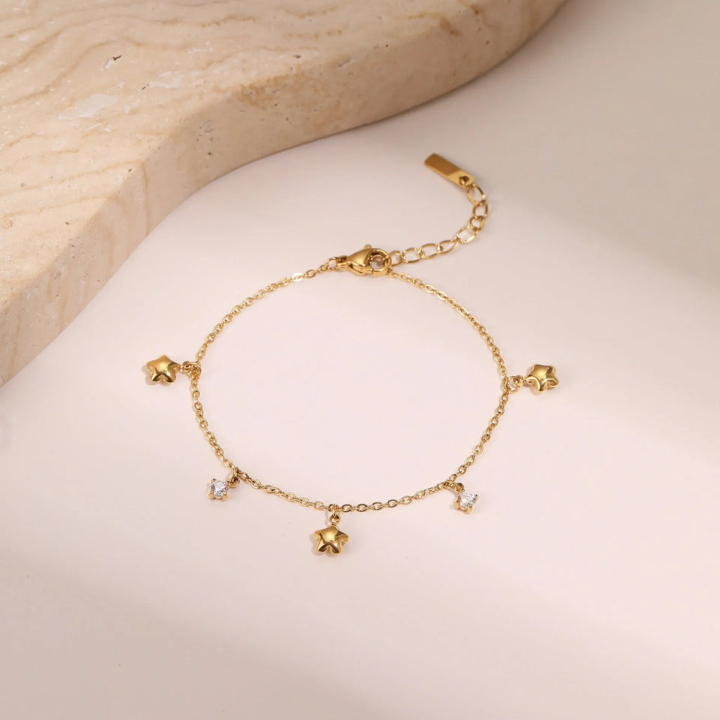Gold-plated titanium steel bracelet with geometric star pendant featuring zircon detailing
