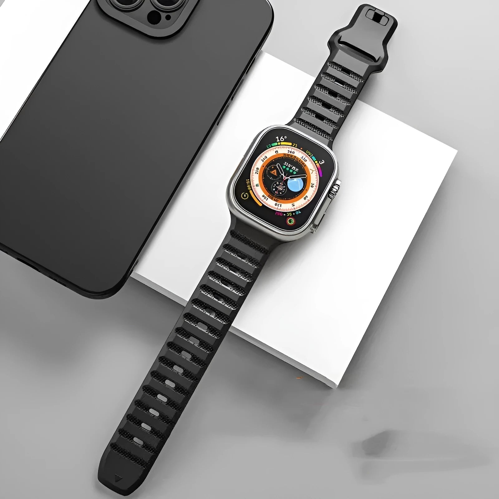 Black fluoro rubber Apple Watch band with T-buckle on a wrist, showing attachment to a watch case.