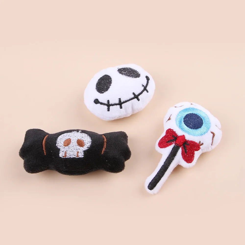 Small plush cat teaser wand with three interchangeable attachments: candy, eyes and skull designs