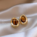 Three pairs of geometric holiday earrings with tassel accents in electroplated alloy
