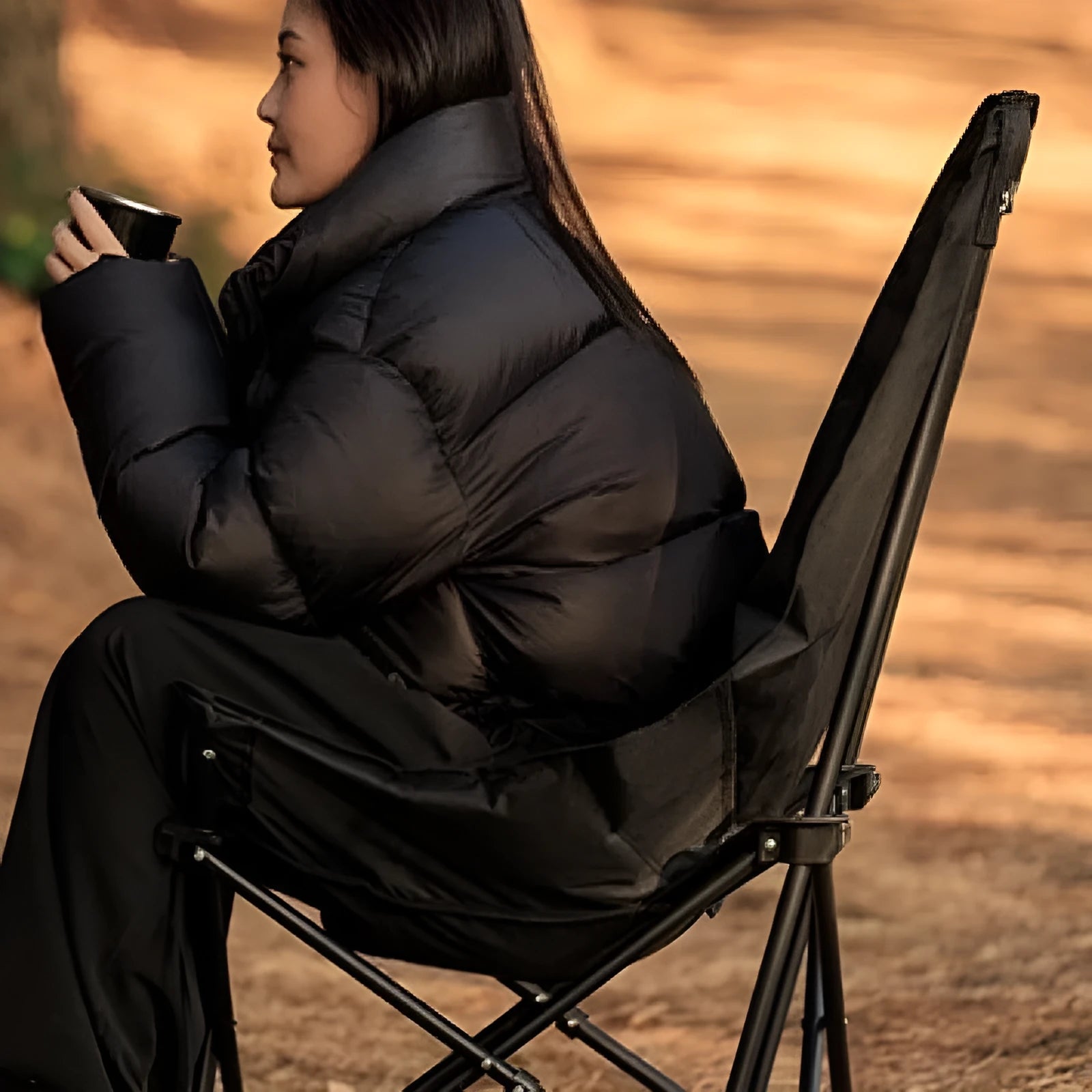 Night Black Oxford cloth folding moon chair in a reclined position on grass.