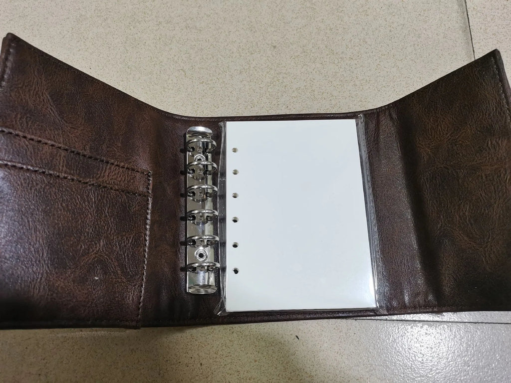 A7 brown PU leather-style notebook with loose-leaf binder binding, open to show 40g raw wood pulp paper