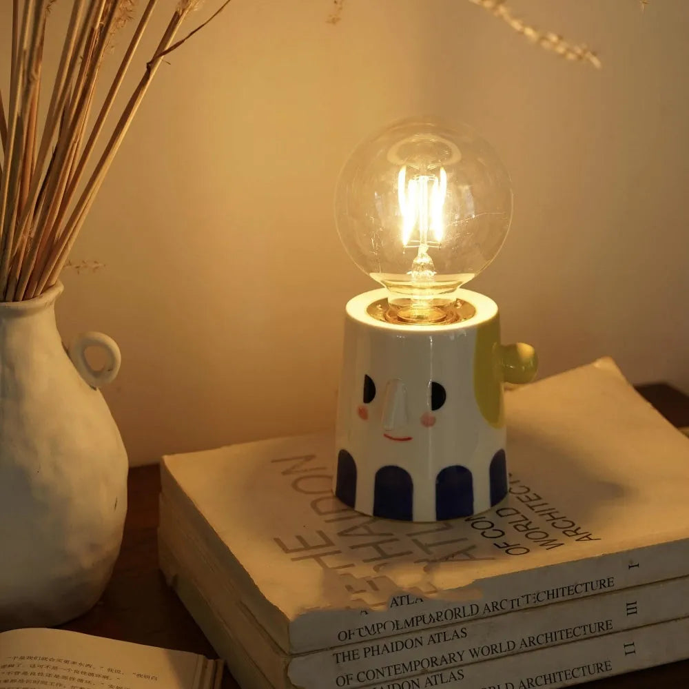 Handmade ceramic bedside lamp with ball-shaped headlight design on wooden surface