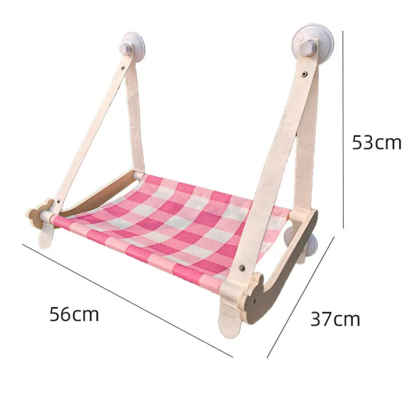 Foldable wooden cat window hammock with suction cups attached to a glass pane.