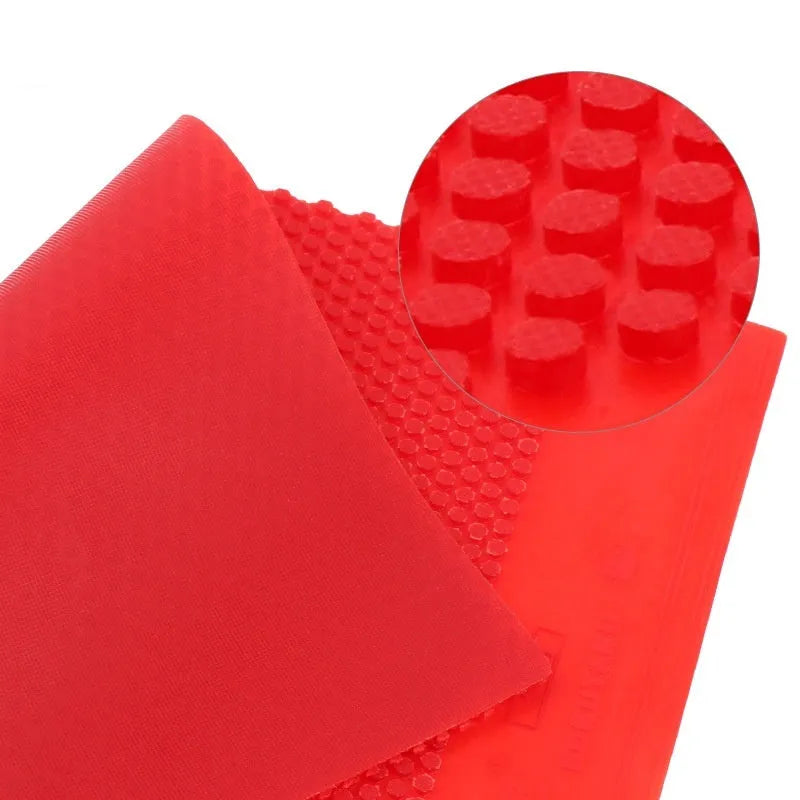 Single square sheet of black table tennis rubber with small pimpled particle texture.