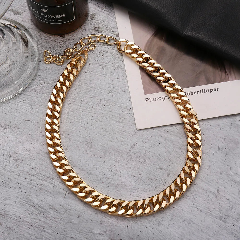 Gold women's thick chain necklace with 32cm length on a plain background.