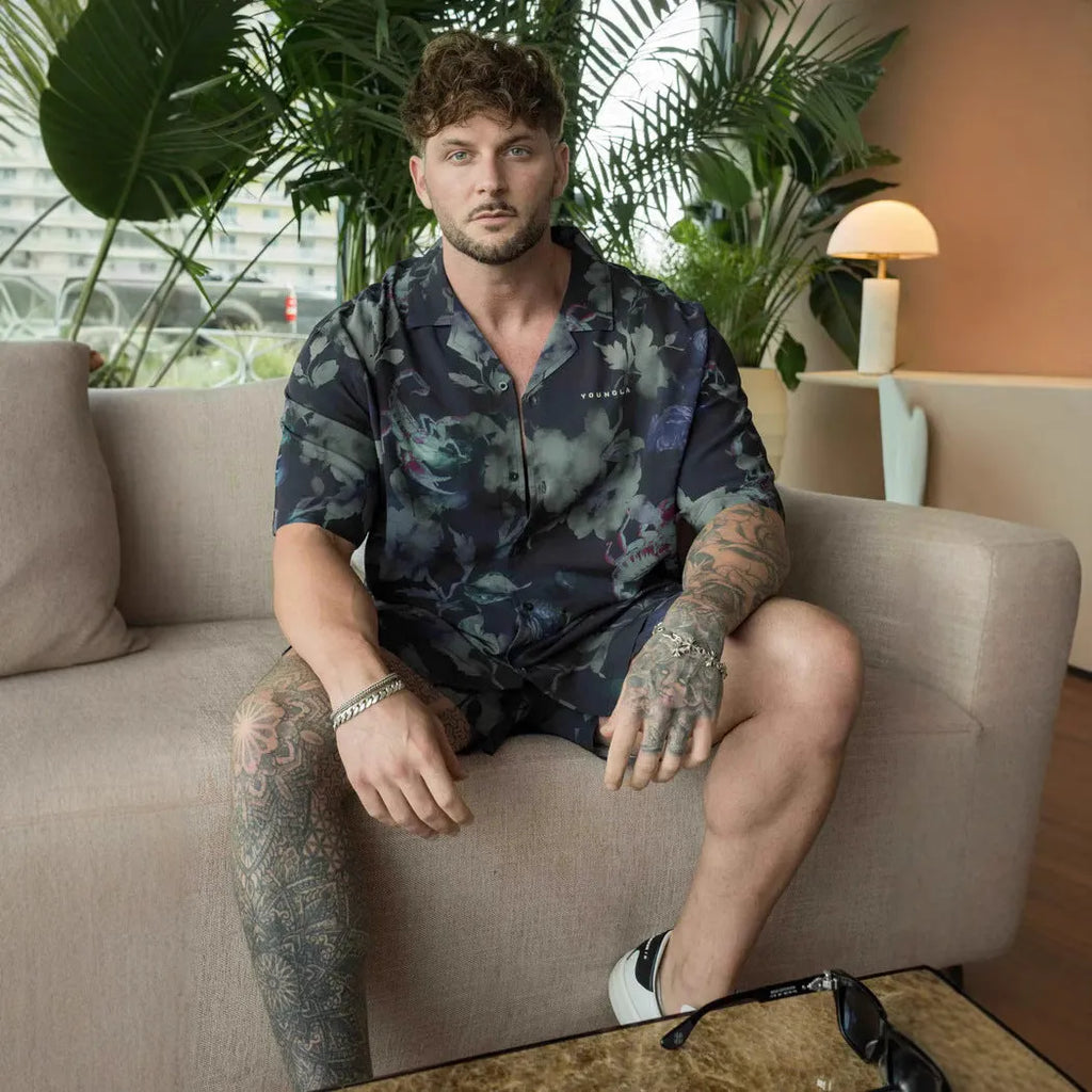 A man's loose-fitting, short-sleeve casual top with a floral print, shown in a neutral colour.