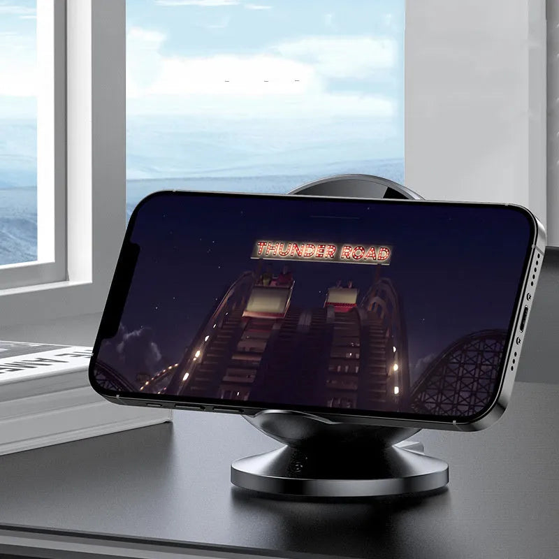 XC-11 black mobile phone wireless charger holder with integrated Bluetooth speaker on a desk.