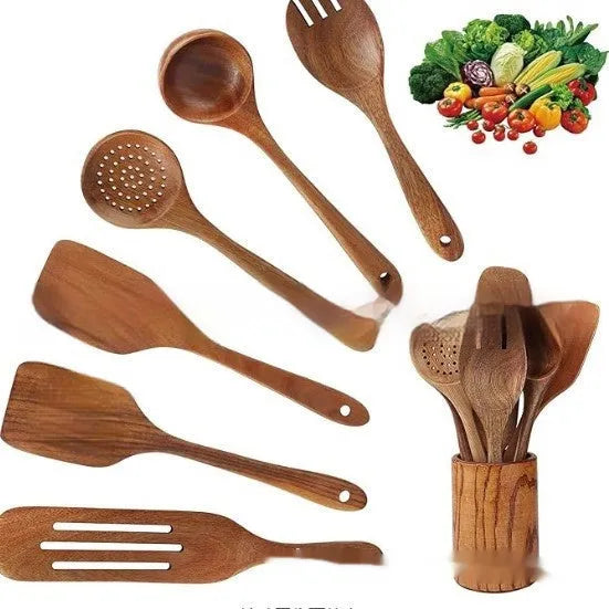 A set of seven wooden kitchen utensils including various spoons and a spatula laid out on a table.