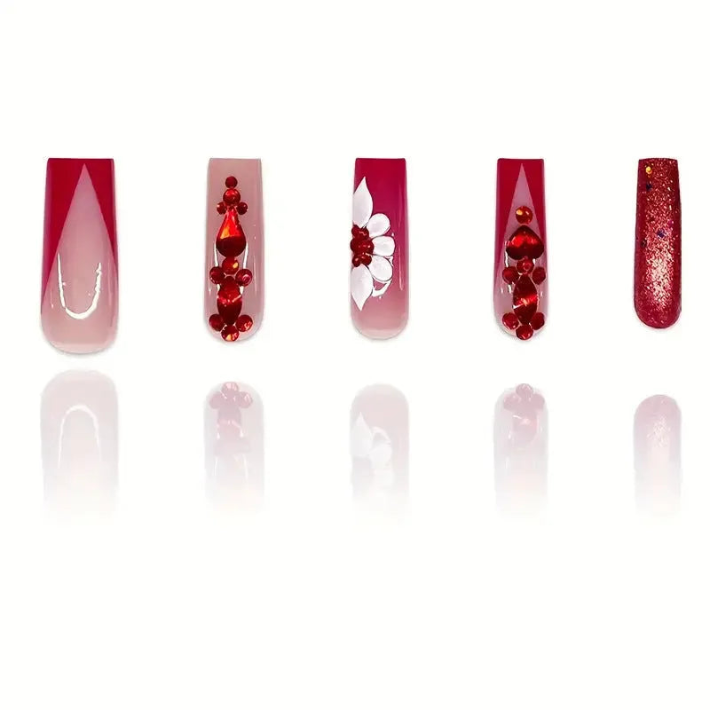 Long coffin shaped press-on false nails with red diamond gemstone and sweet flower pattern decoration.