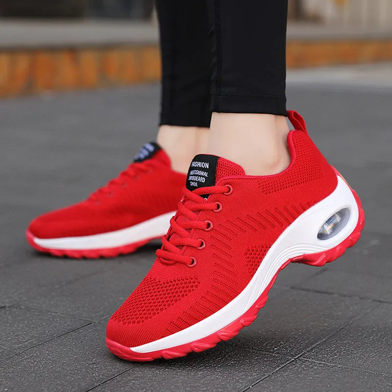 Women's red low-top lace-up mesh sneakers with round toe and a visible mid-height sole.