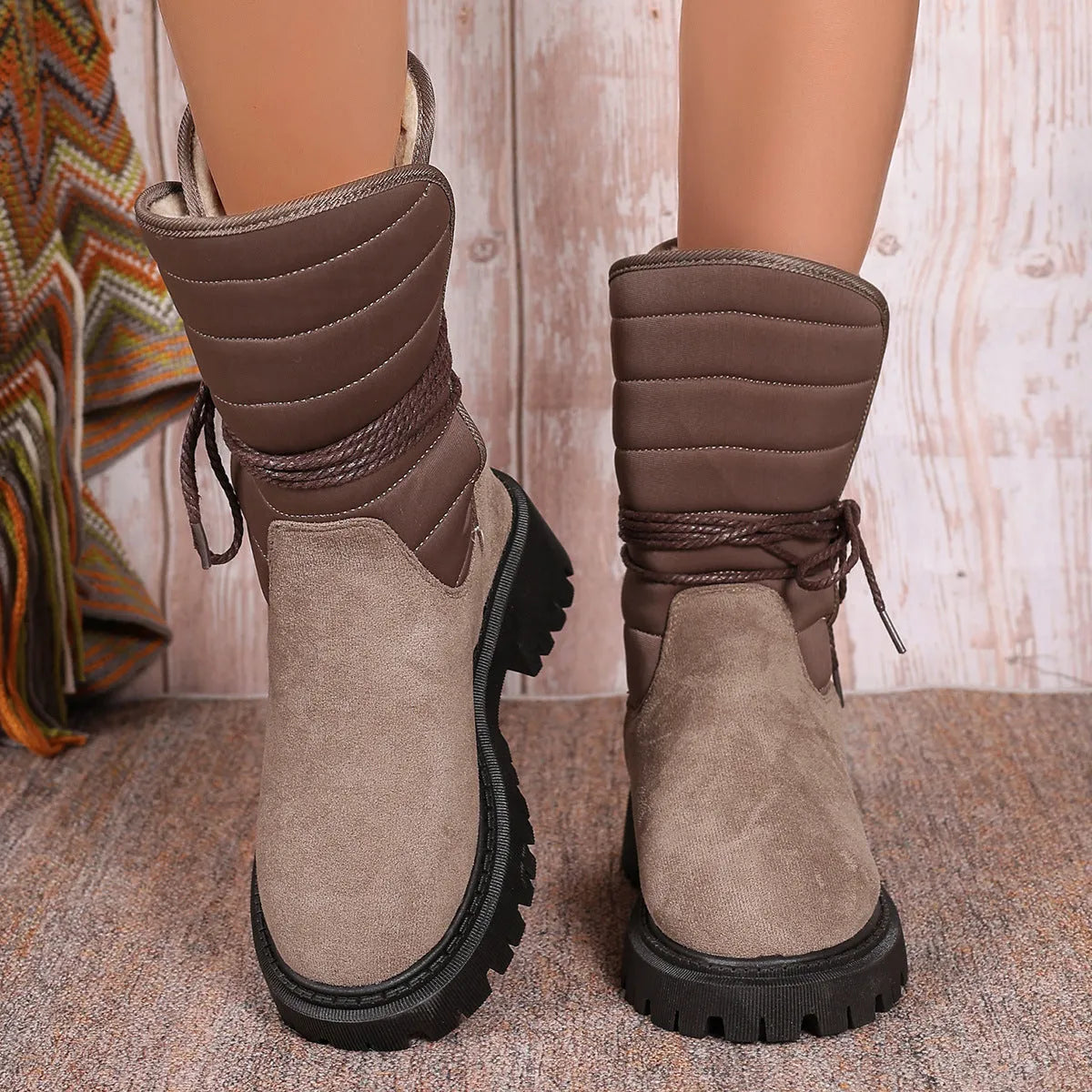 Women's black suede snow boots with chunky heel and lace-up design showing fleece lining