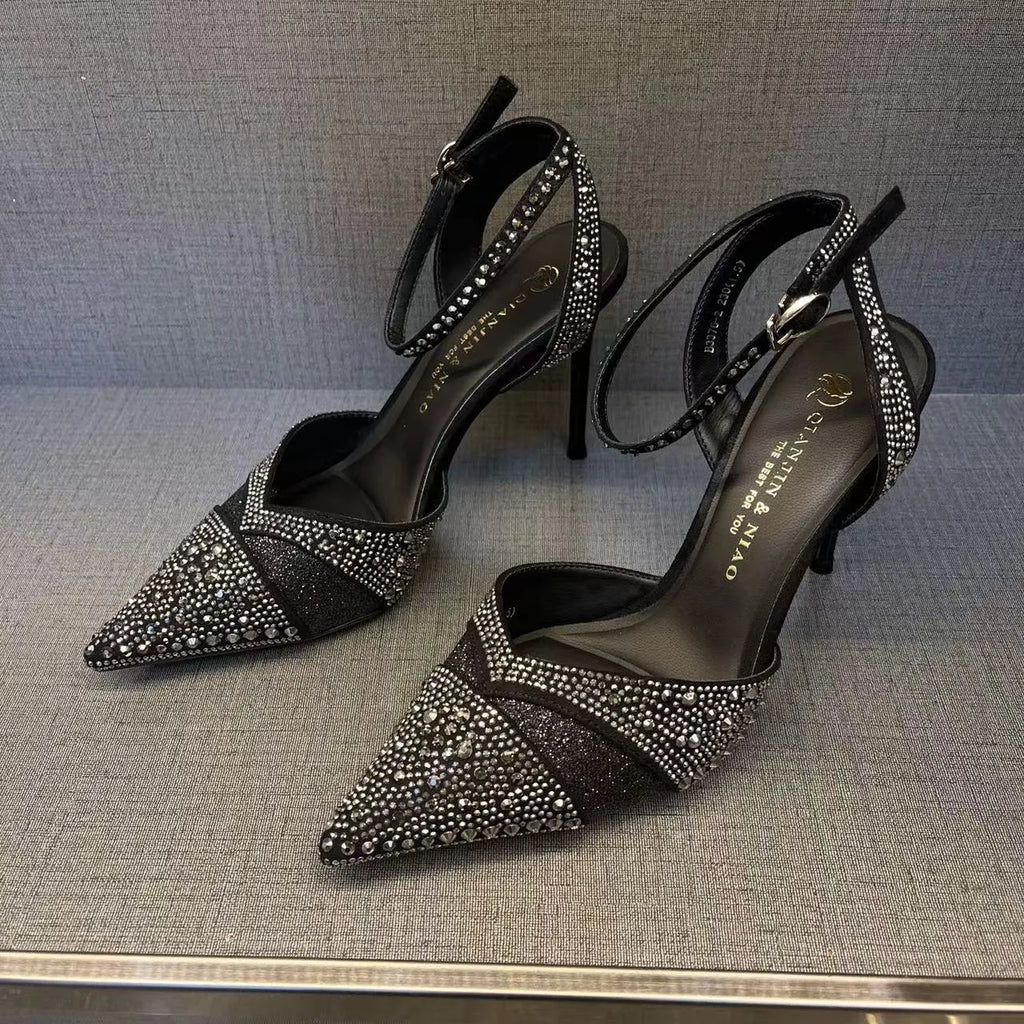 Black women's hollow high heels with pointed toe, stiletto heel, and red sole on a plain background.