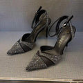 Black women's hollow high heels with pointed toe, stiletto heel, and red sole on a plain background.