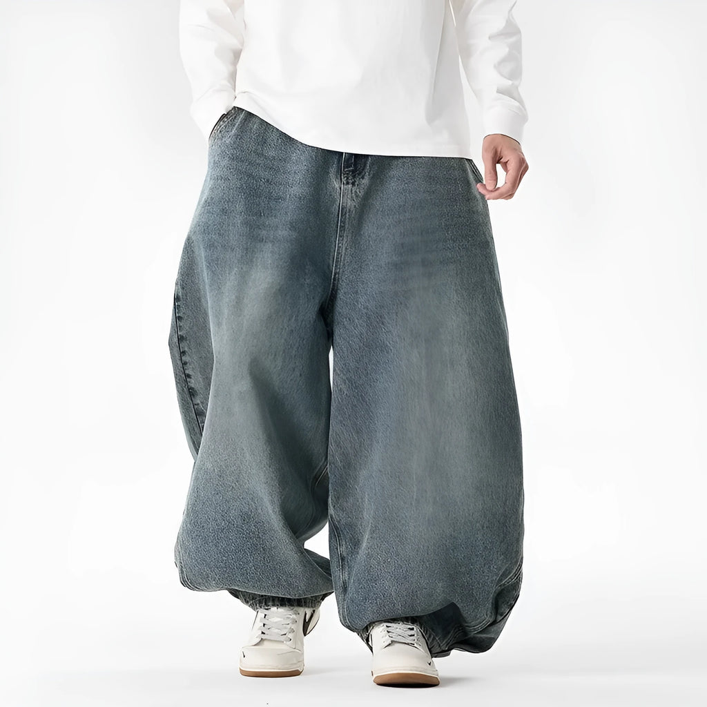 Men's plus size baggy blue jeans with wide straight legs on a hanger.
