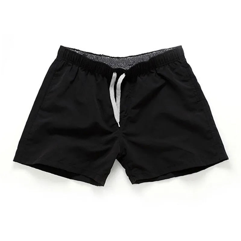 Men's straight leg beach shorts in polyester, shown in multiple colours including fluorescent yellow and navy blue.