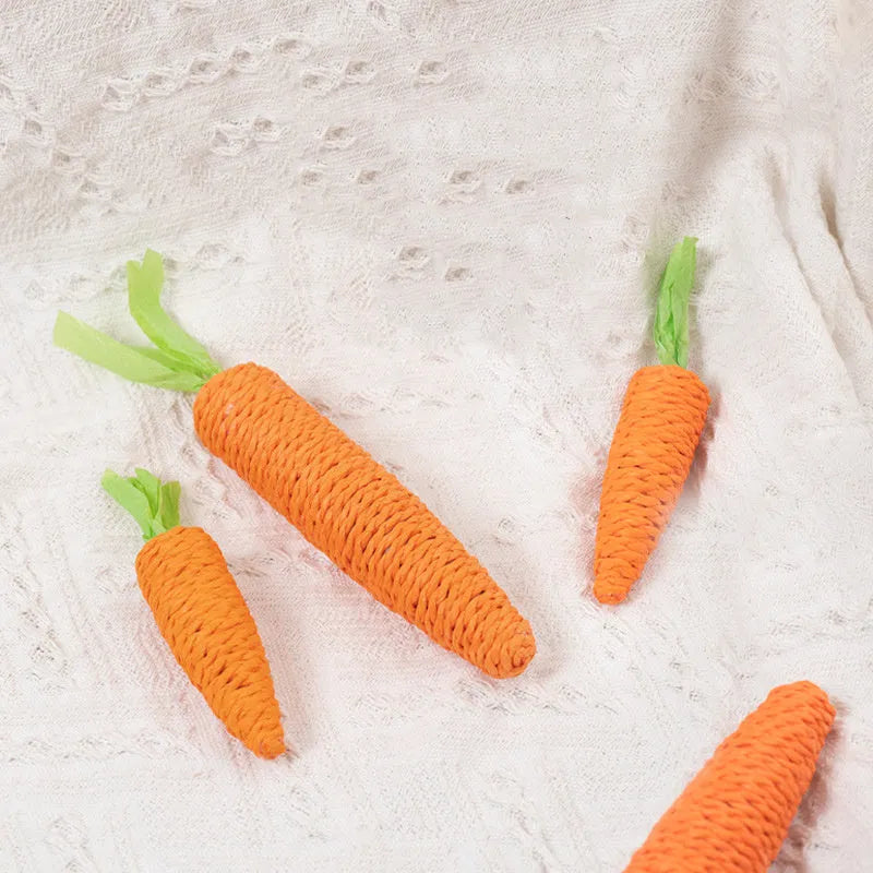 Set of cat toys including carrot shapes, crinkly paper balls, ringing stones, and dental grinding sticks in two sizes.