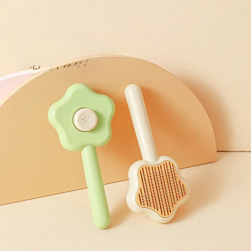 Green handle self-cleaning stainless steel needle comb for cats on a white background
