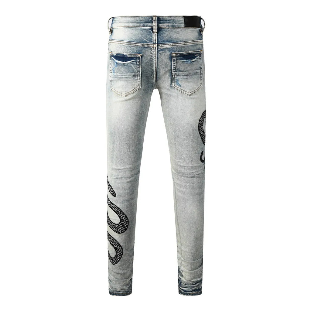 Close-up of vintage blue wash distressed skinny jeans with a tapered leg and button fly.
