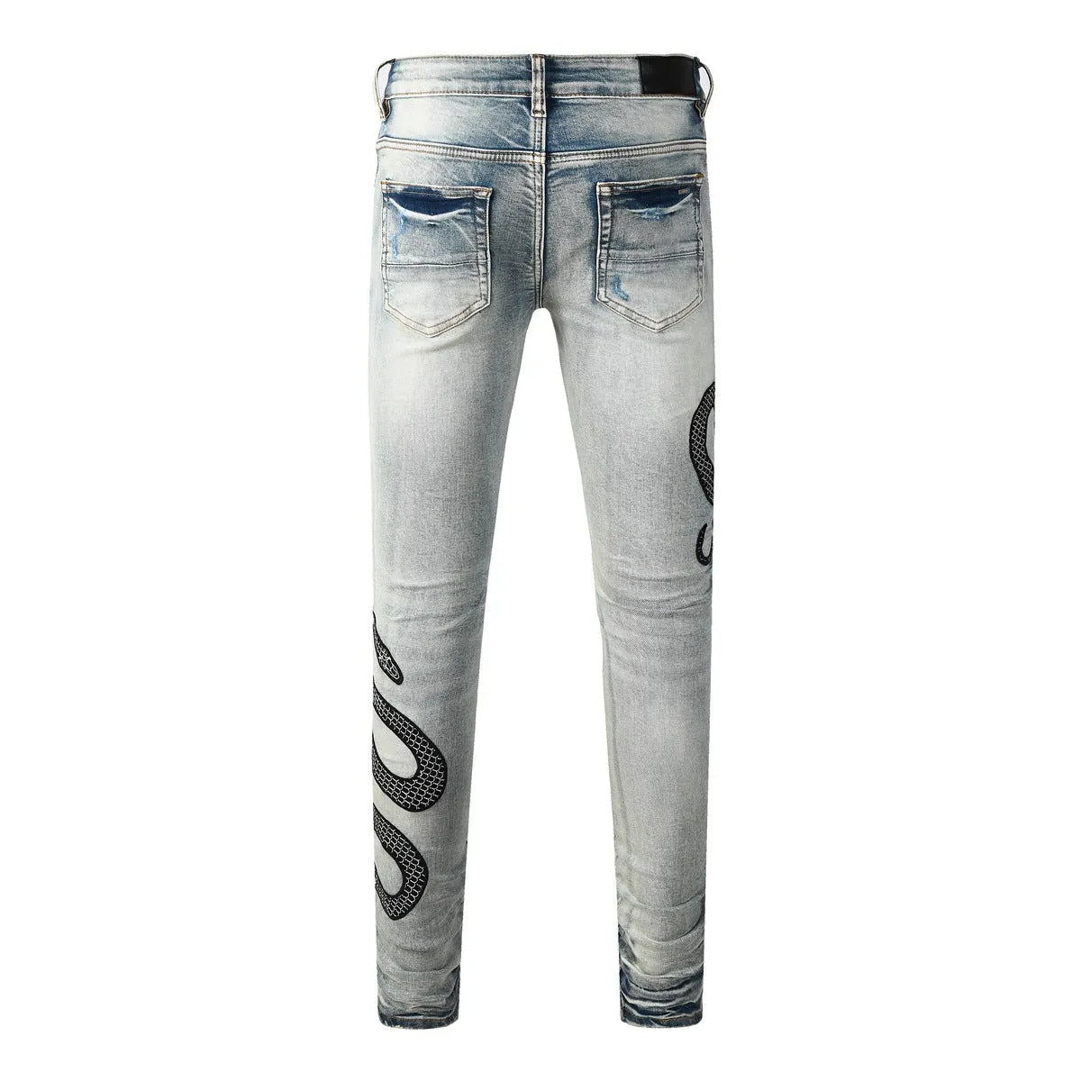 Close-up of vintage blue wash distressed skinny jeans with a tapered leg and button fly.