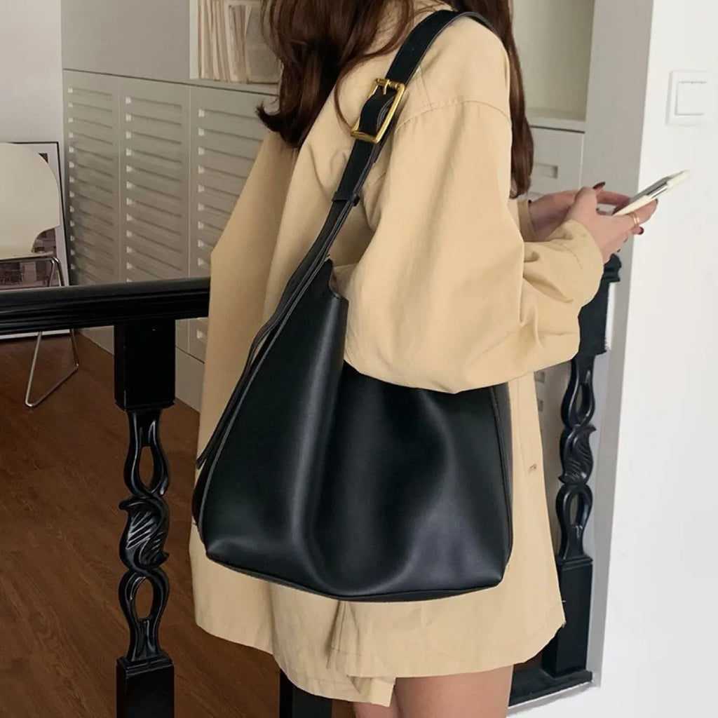 Two women's fashion shoulder bags: black with ribbon and brown with packet designs showing swing thread details