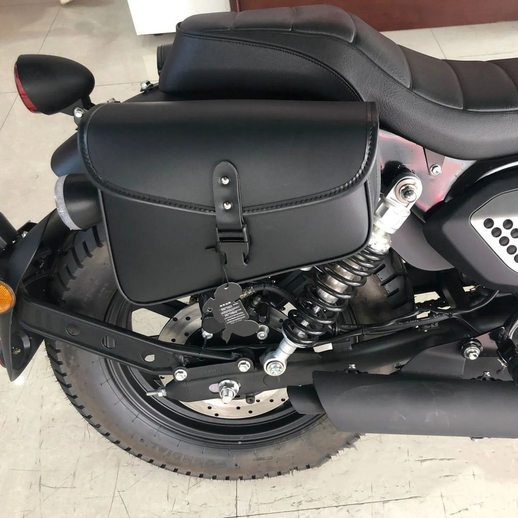 Black PU leather motorcycle swingarm saddlebag mounted on a Harley Sportster, showing side storage compartment.