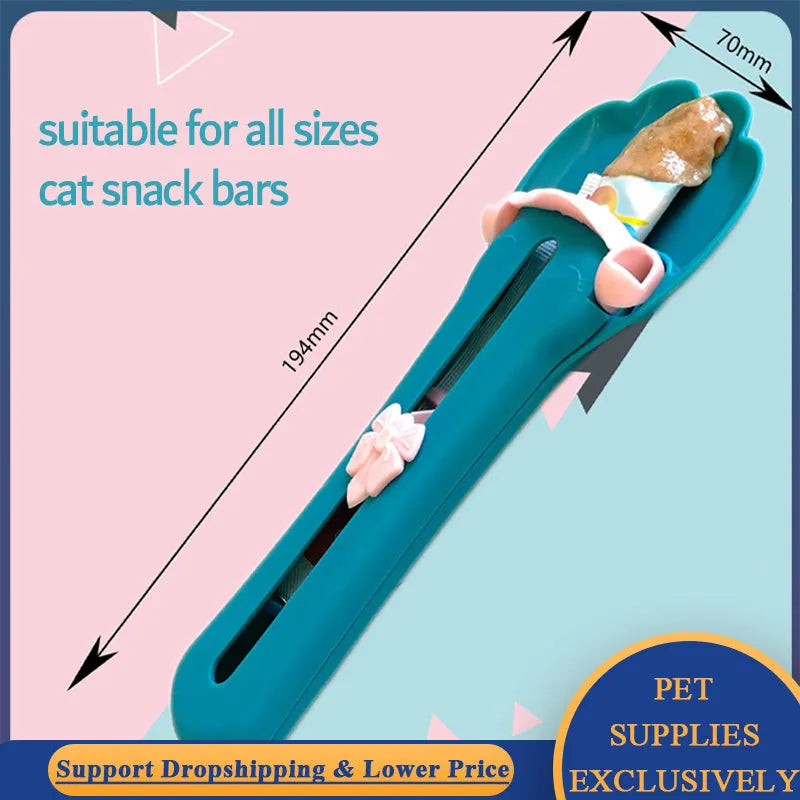 Green and pink handheld pet food squeezer spoon feeder for cats and dogs.