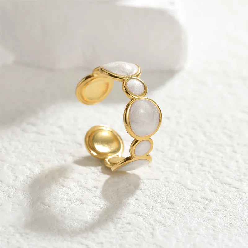Silver-tone geometric stainless steel ring with an adjustable opening on a plain background.