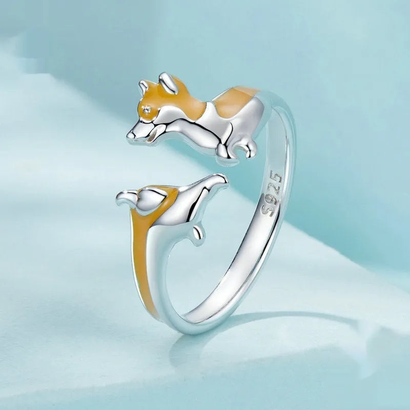 Close-up of a silver-coloured adjustable ring with a detailed cartoon corgi dog design on its face.