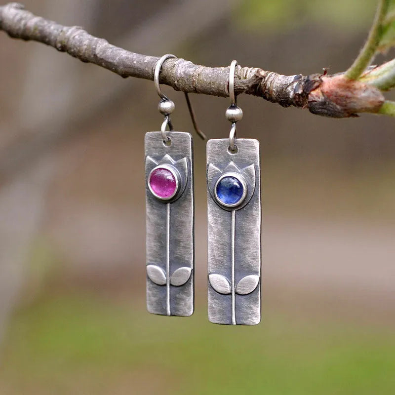 A pair of antique finish red sapphire geometric drop earrings with an elliptical design in a retro style